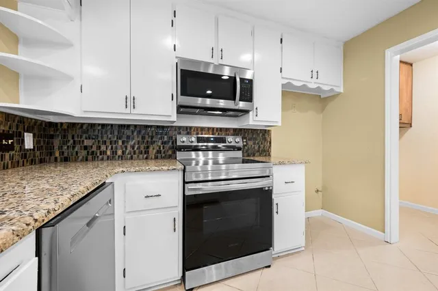 a kitchen with stainless steel appliances granite countertop a sink stove and microwave