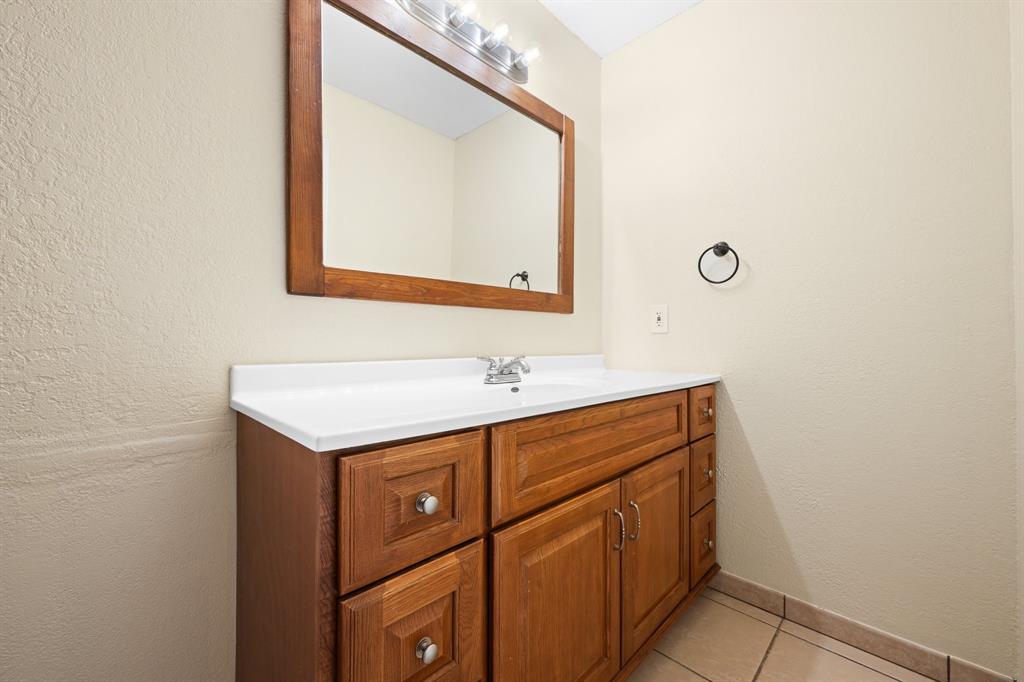 1102 Lena Street Cleburne, TX 76033 - Photo 19 of 36 a bathroom with a sink and a mirror