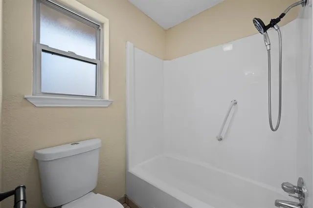 a bathroom with a granite countertop toilet a sink and bathtub