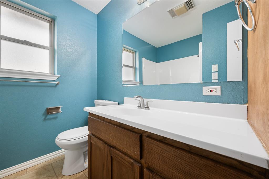 1102 Lena Street Cleburne, TX 76033 - Photo 25 of 36 a bathroom with a sink a toilet and a bathtub
