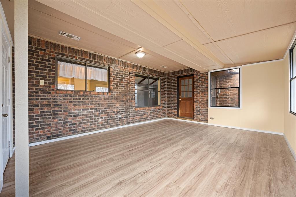 1102 Lena Street Cleburne, TX 76033 - Photo 27 of 36 an empty room with wooden floor and windows