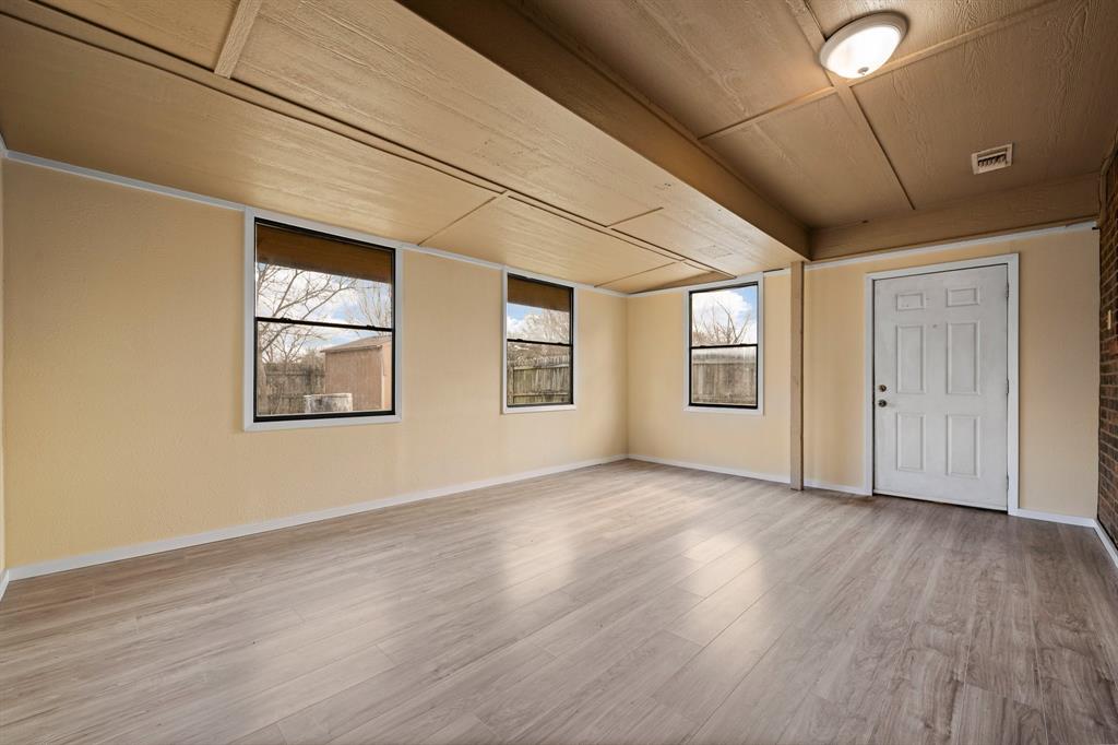1102 Lena Street Cleburne, TX 76033 - Photo 30 of 36 a view of an empty room with wooden floor and windows