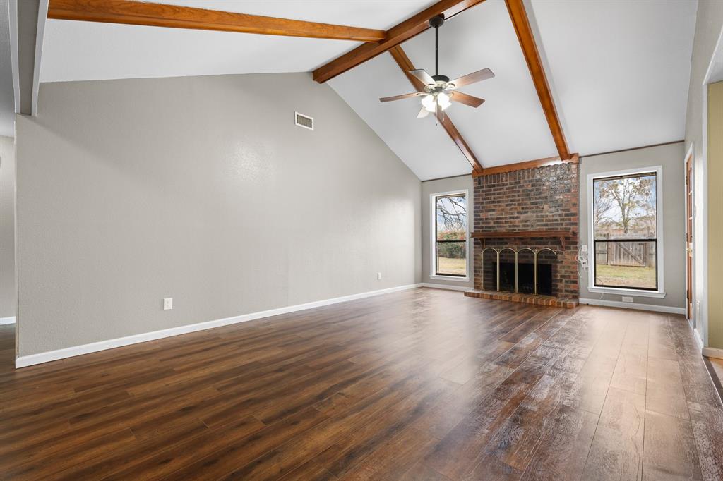1102 Lena Street Cleburne, TX 76033 - Photo 3 of 36 a view of an empty room with wooden floor fireplace and a window
