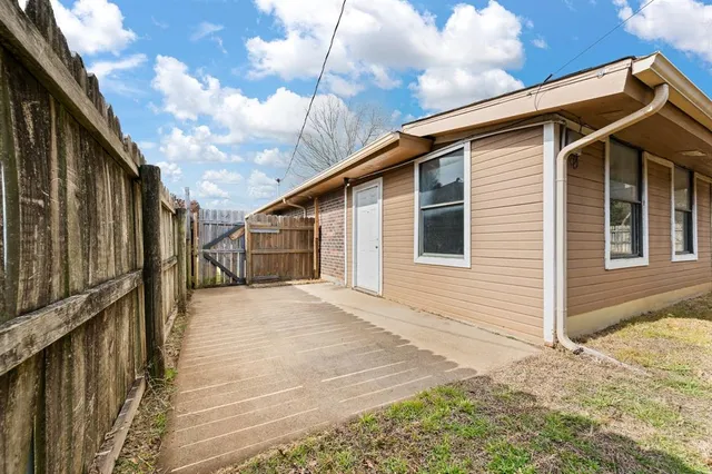 a view of a house with wooden fence