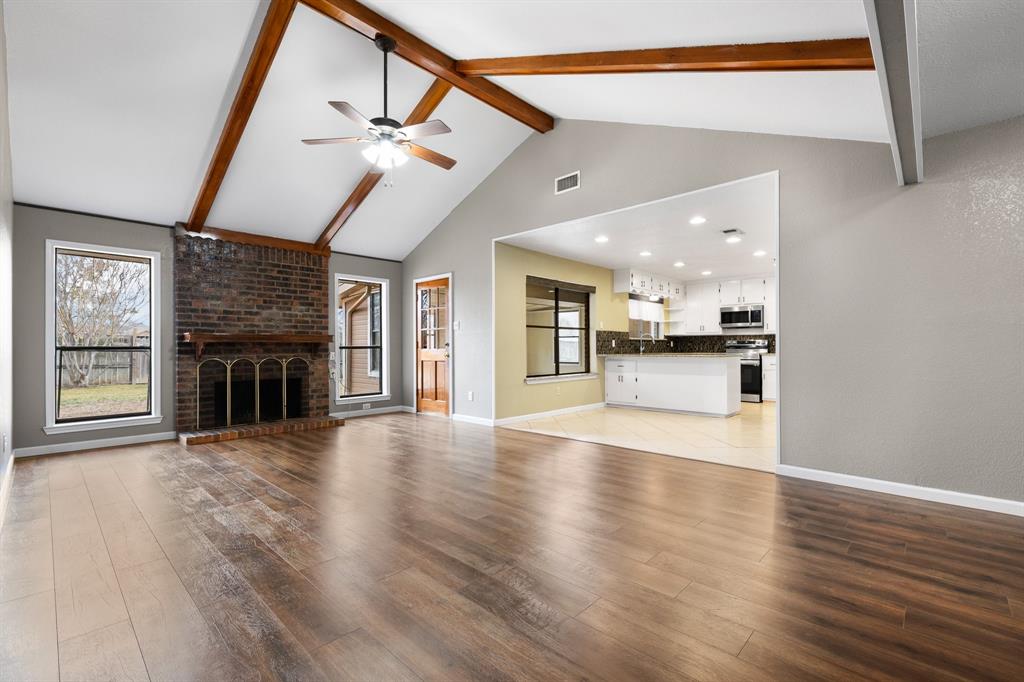 1102 Lena Street Cleburne, TX 76033 - Photo 4 of 36 a view of a hall with wooden floor and a kitchen