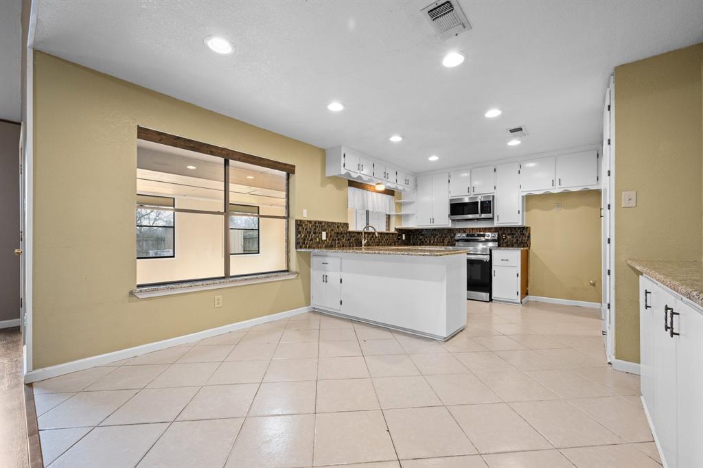 1102 Lena Street Cleburne, TX 76033 - Photo 8 of 36 a large kitchen with stainless steel appliances granite countertop a stove a sink and a refrigerator