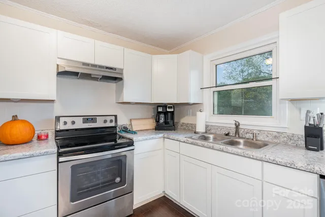 a kitchen with stainless steel appliances a stove a sink and a microwave