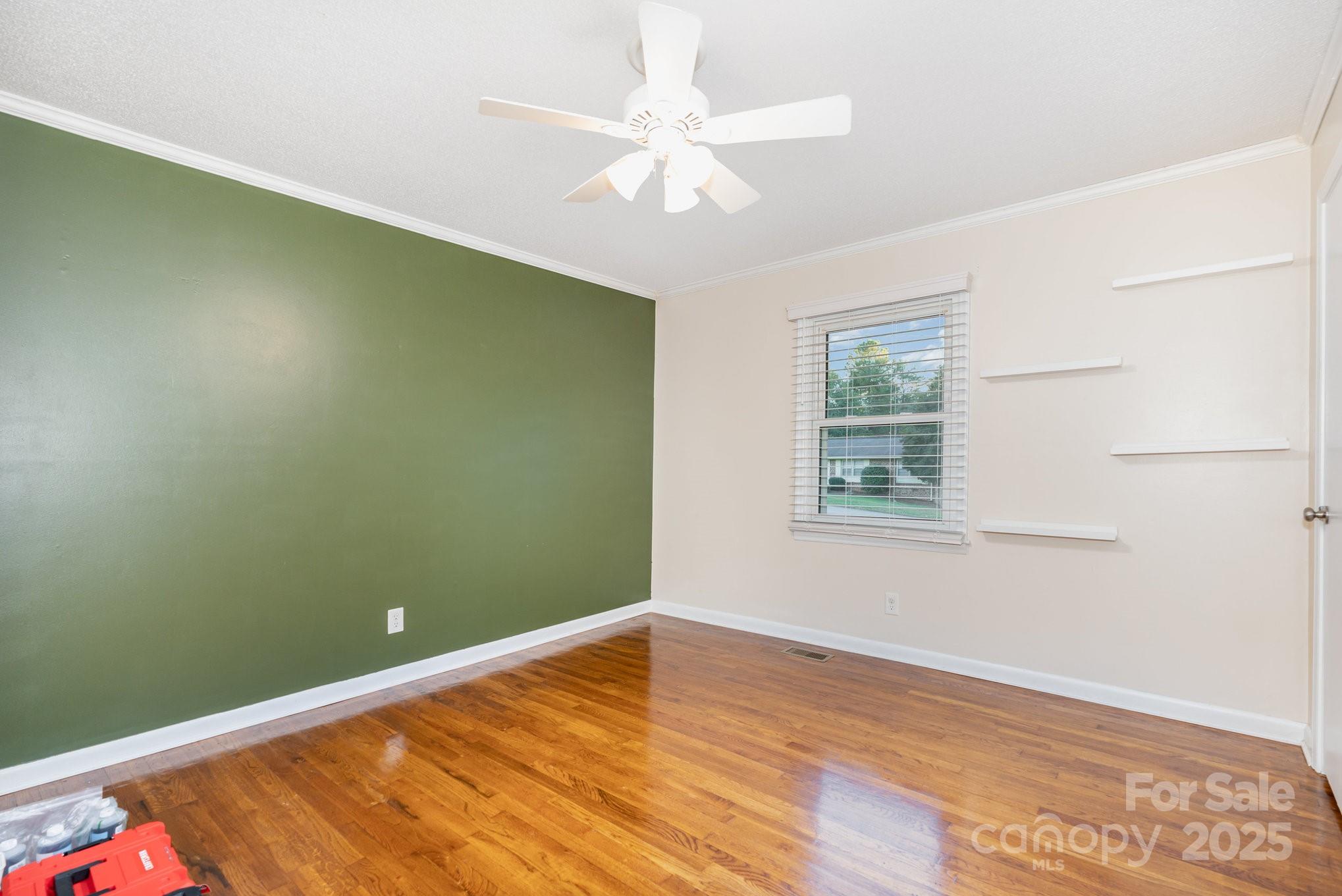 512 Ralphs Boulevard Gastonia, NC 28052 - Photo 22 of 32 an empty room with wooden floor fan and windows