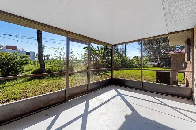 a view of an empty room with wooden floor and windows