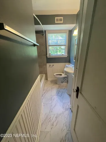 a bathroom with a toilet and a shower