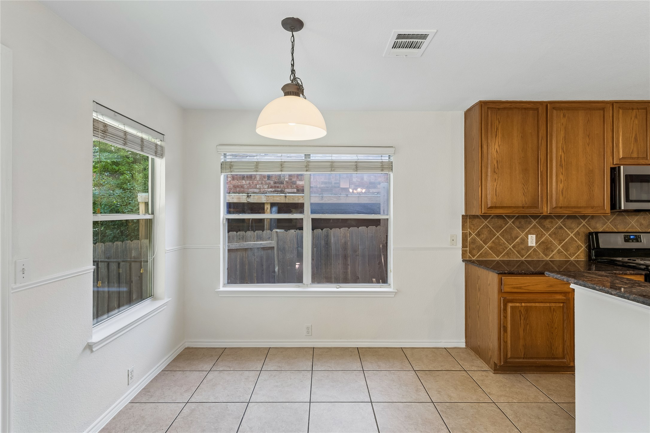 2372 Paradise Ridge Drive Round Rock, TX 78665 - Photo 9 of 40 A well-lit eat-in kitchen area features tile flooring and ample natural light from multiple windows.