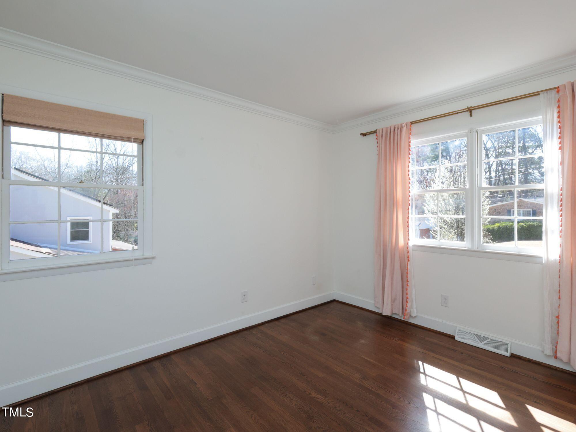 529 Harvard Street Raleigh, NC 27609 - Photo 20 of 48 a view of an empty room with wooden floor and a window