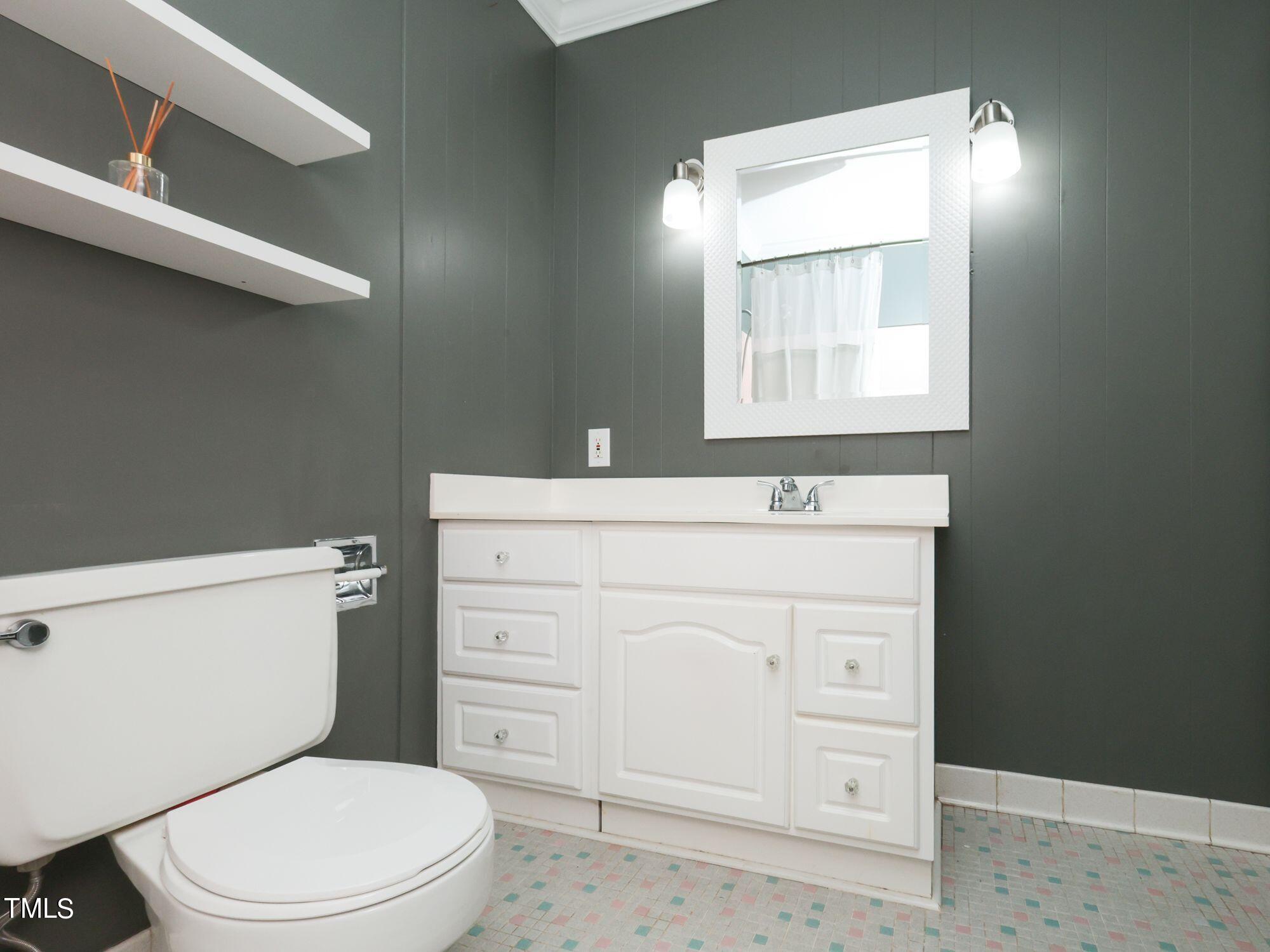 529 Harvard Street Raleigh, NC 27609 - Photo 30 of 48 a bathroom with a toilet a sink a vanity and mirror