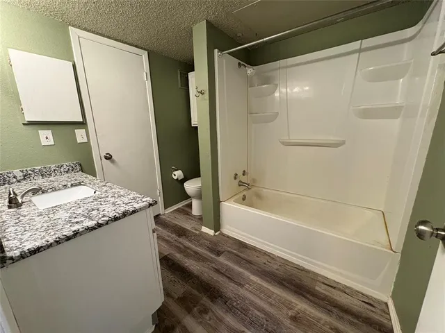 a bathroom with a granite countertop sink toilet and shower