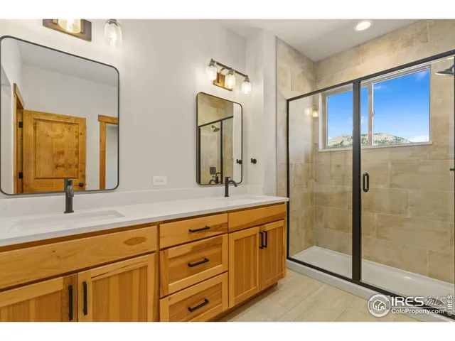 a bathroom with a double vanity sink mirror and shower