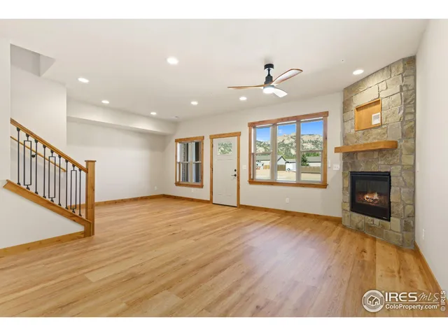 a view interior of a house wooden floor fire place and a ceiling fan