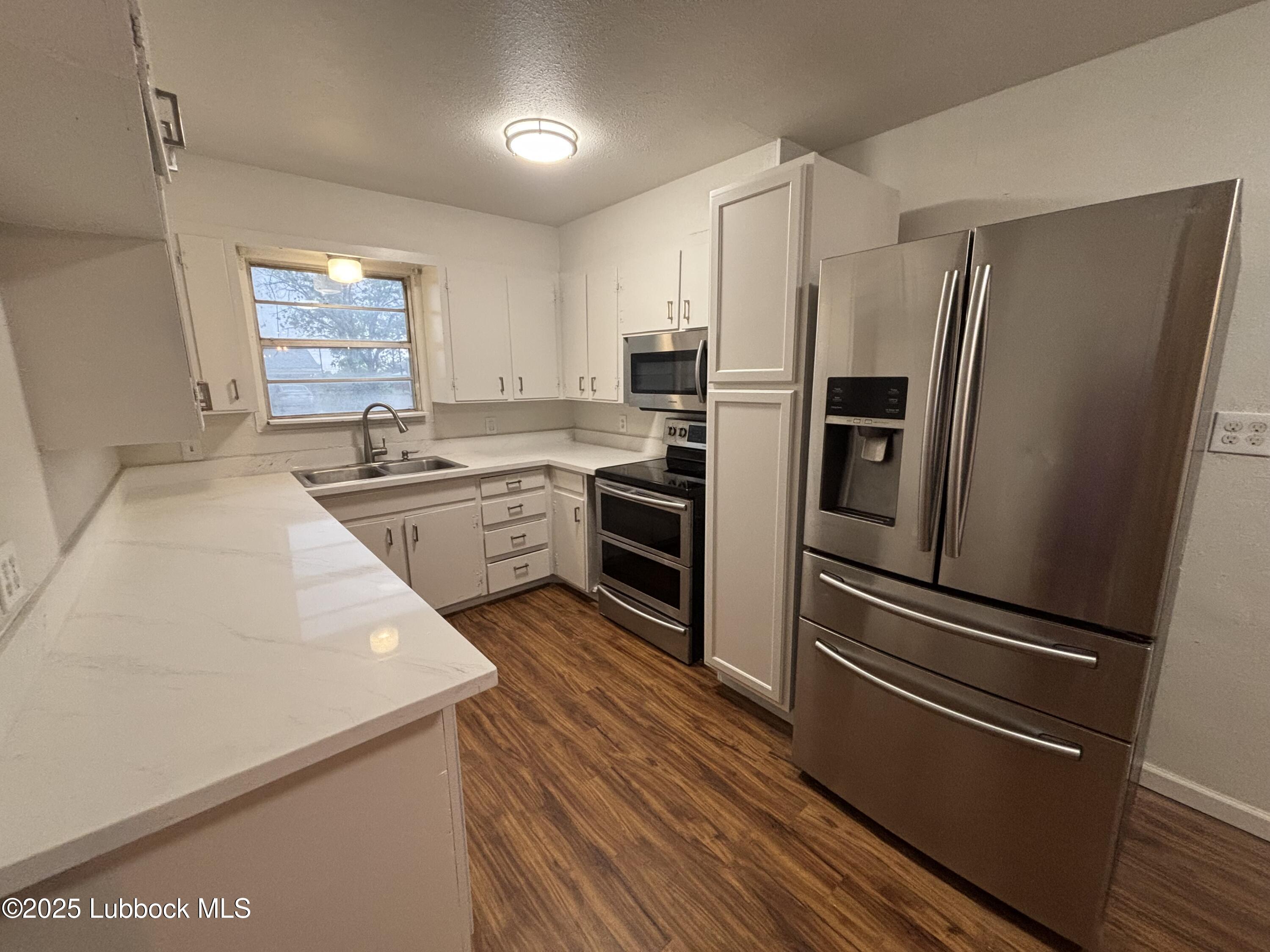 1301 6th Street Shallowater, TX 79363 - Photo 3 of 15 a kitchen with stainless steel appliances a refrigerator sink and microwave