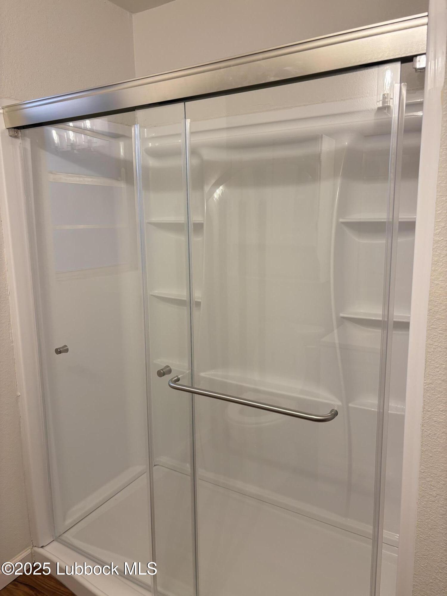 1301 6th Street Shallowater, TX 79363 - Photo 8 of 15 a bathroom with a glass shower door