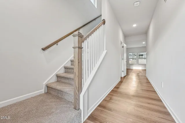 a view of a hallway with wooden floor and entryway