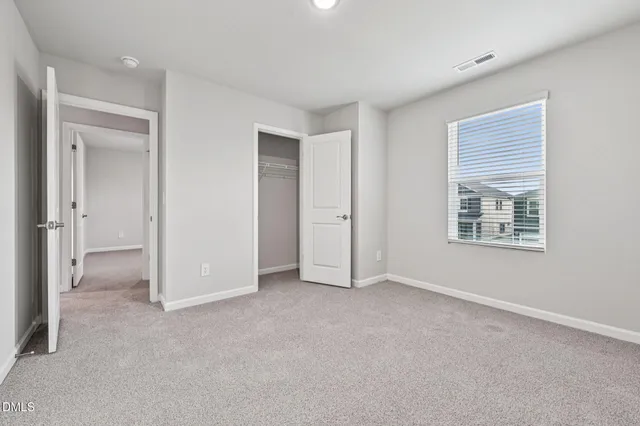 an empty room with windows and closet