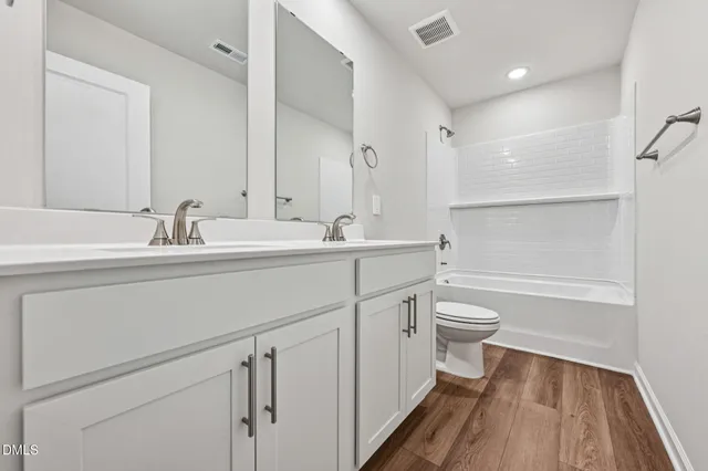 a bathroom with a sink a toilet a mirror and shower