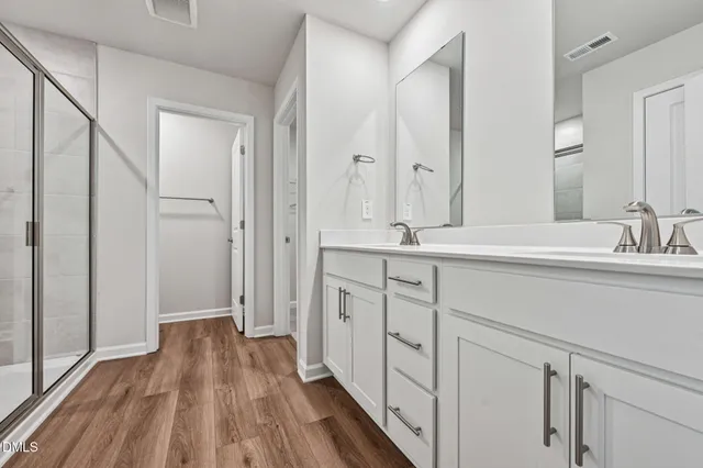 a spacious bathroom with a double vanity sink and mirror