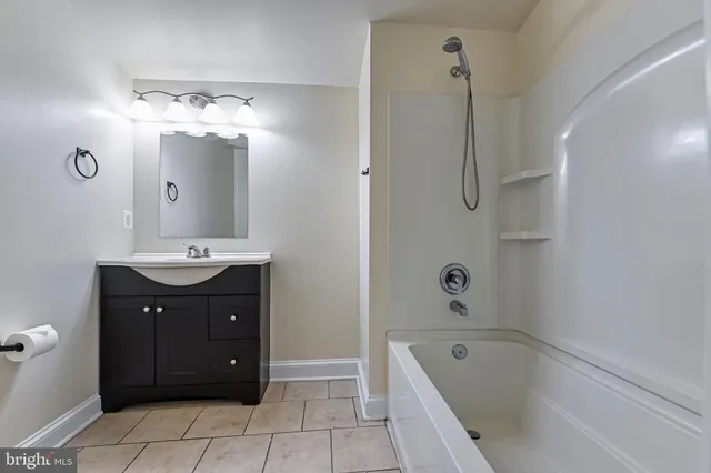 a bathroom with a tub sink and mirror