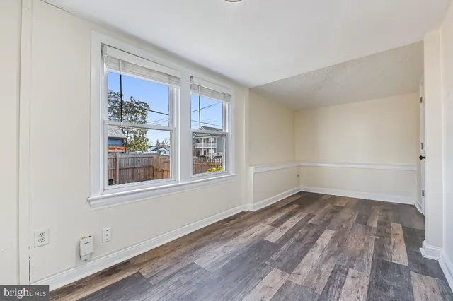 a view of a room that has wooden floor and windows in it
