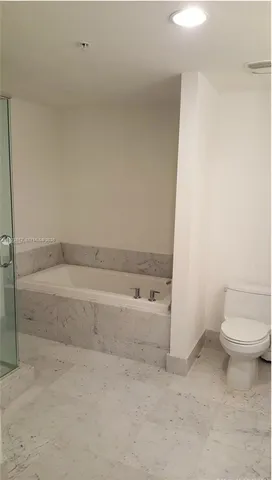 a spacious bathroom with a bathtub and toilet
