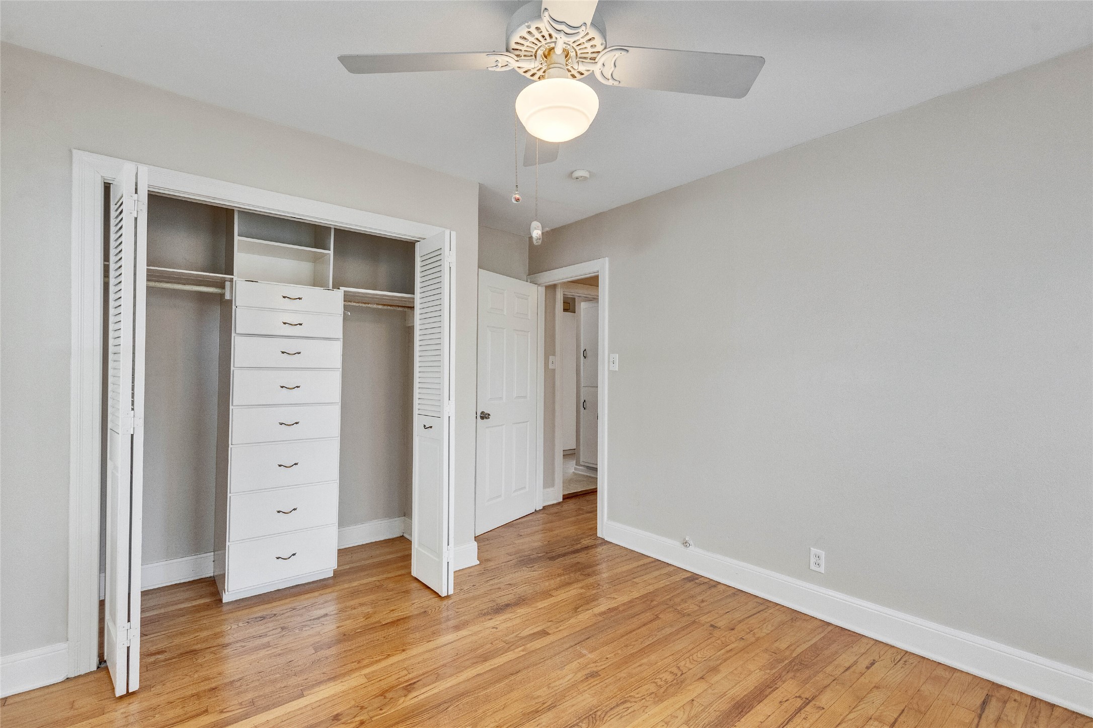 3810 Brookview Road Austin, TX 78722 - Photo 15 of 27 Rich hardwood flooring complements the simple lines of this quiet bedroom with a closet organizer.