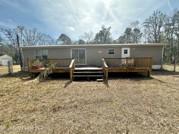 a view of a house with a wooden deck