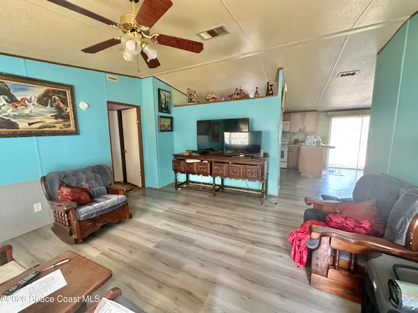 a living room with furniture and a wooden floor