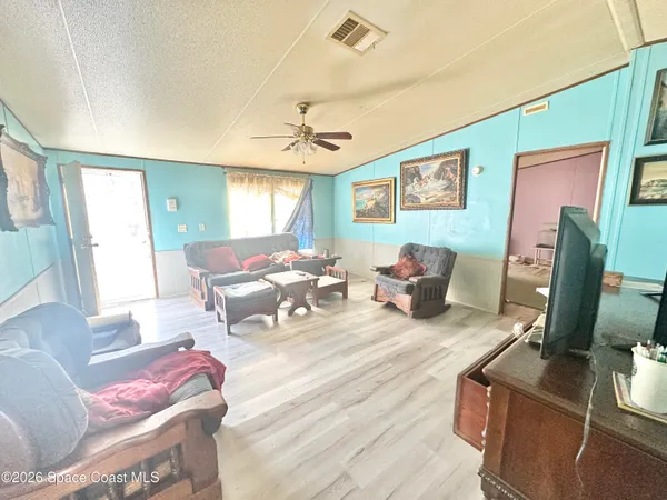 a living room with furniture a flat screen tv and a window