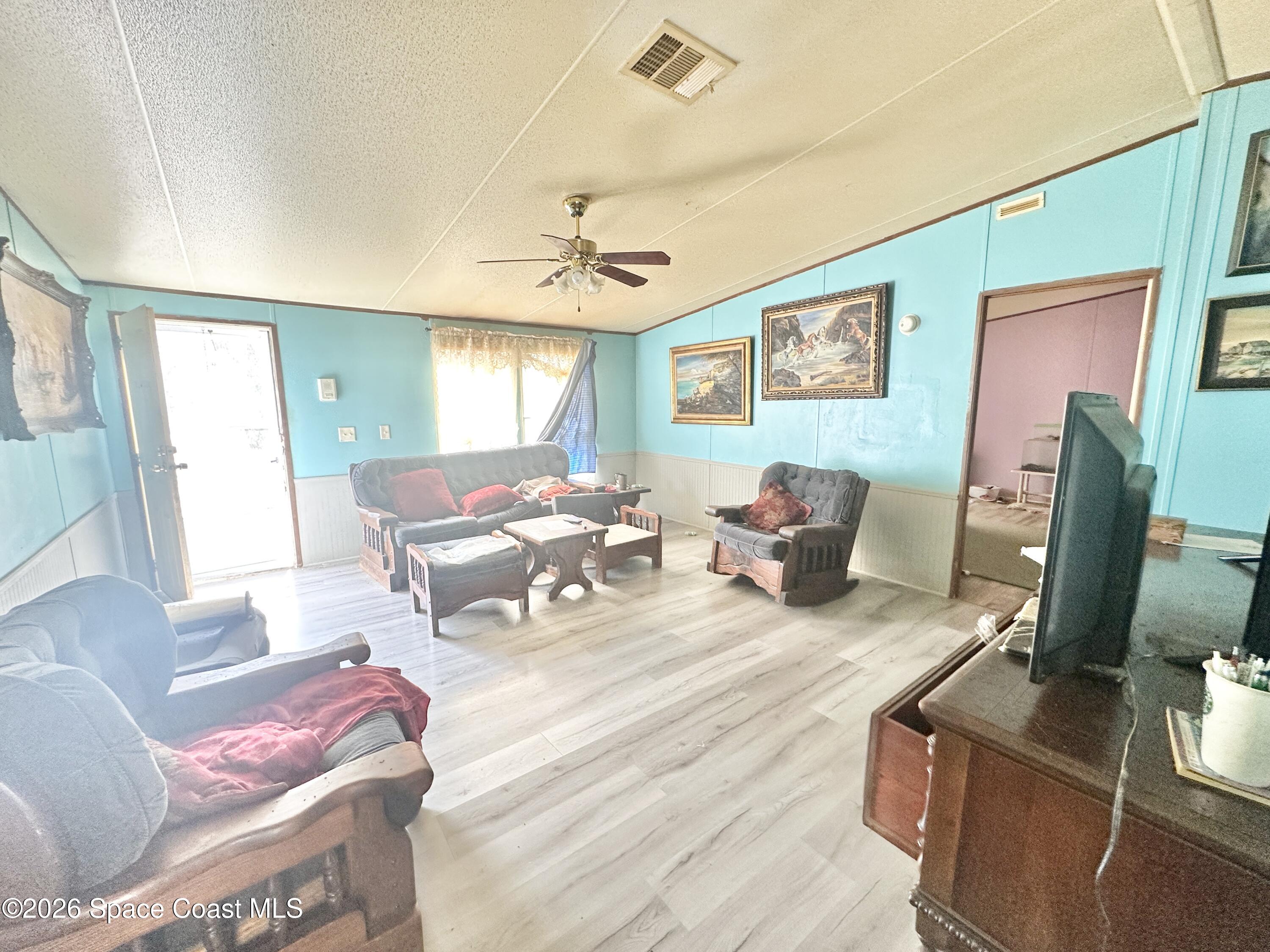 3550 Arbor Avenue Bunnell, FL 32110 - Photo 6 of 21 a living room with furniture a flat screen tv and a window