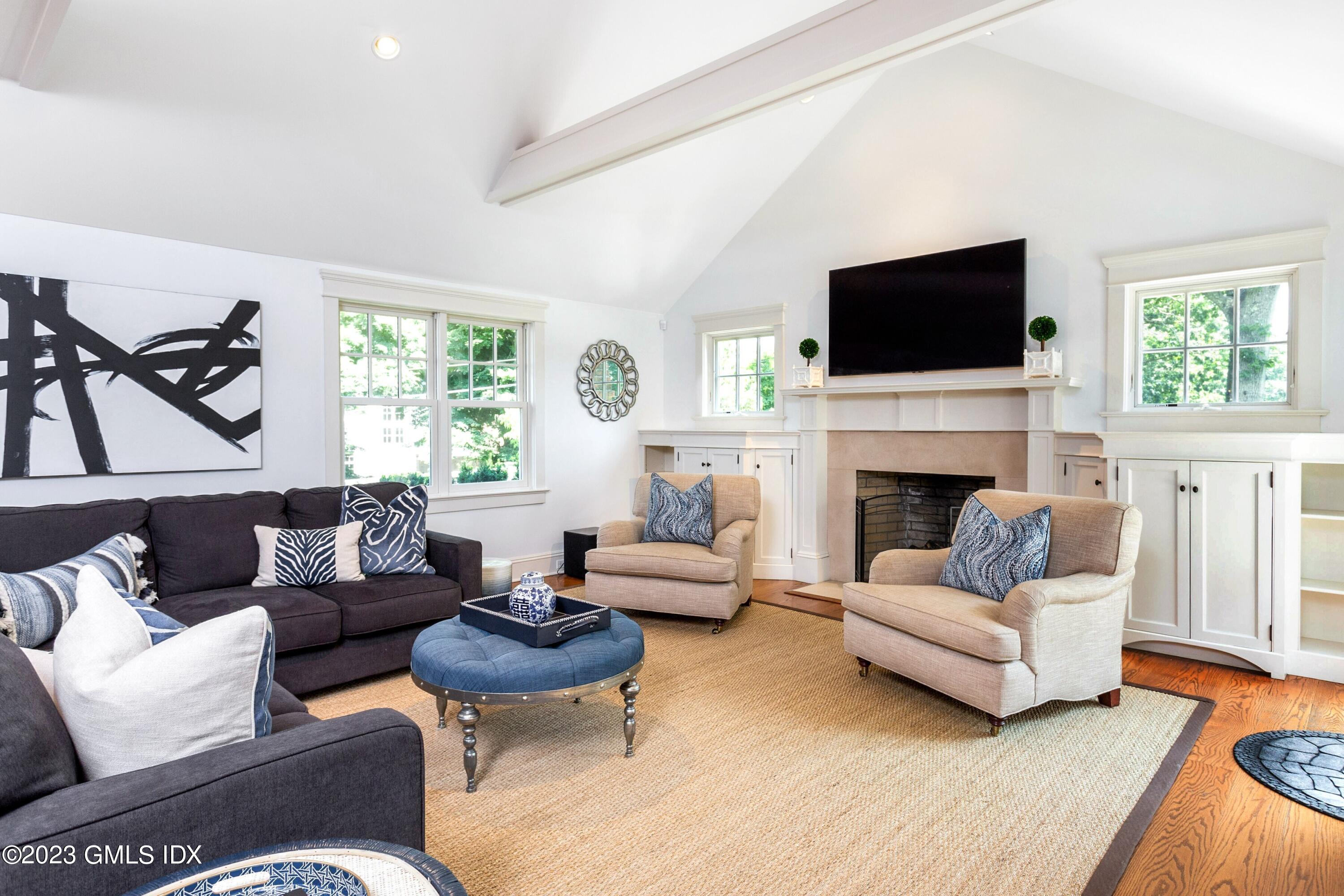 150 Goodwives River Road Darien, CT 06820 - Photo 14 of 39 a living room with furniture a flat screen tv and a fireplace