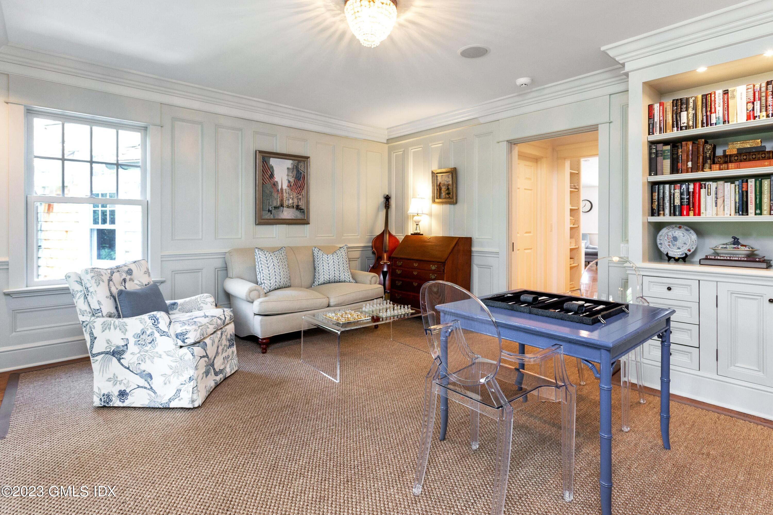 150 Goodwives River Road Darien, CT 06820 - Photo 16 of 39 a living room with furniture a bookshelf and a window