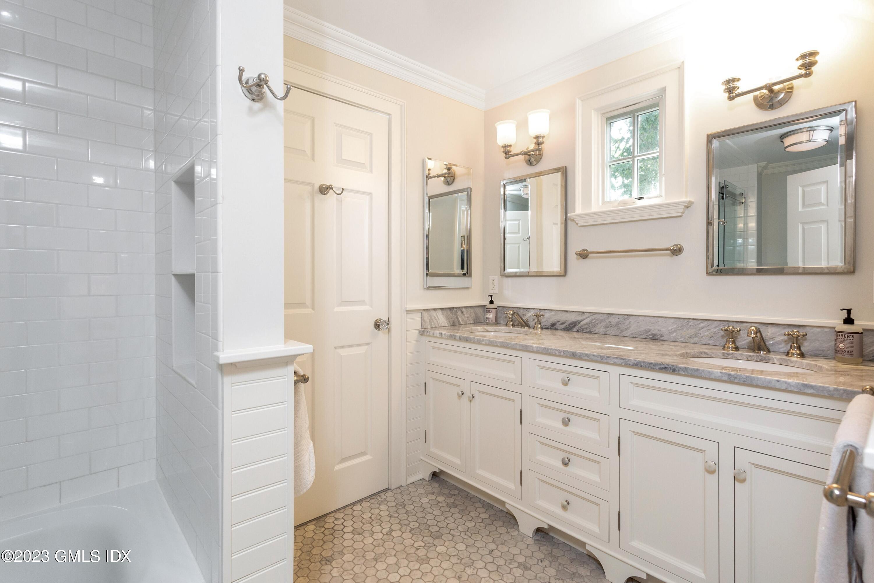 150 Goodwives River Road Darien, CT 06820 - Photo 24 of 39 a bathroom with a granite countertop sink two mirror and a shower