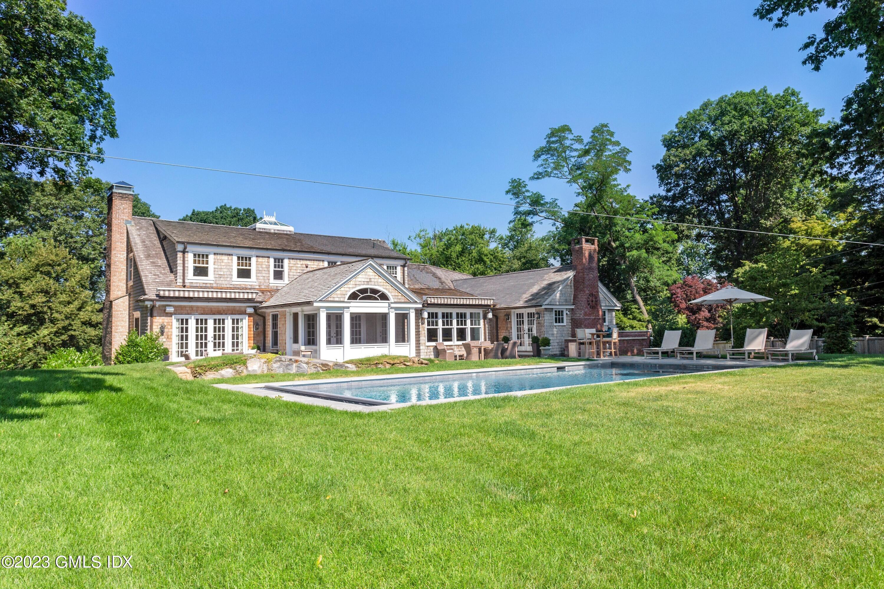 150 Goodwives River Road Darien, CT 06820 - Photo 35 of 39 a front view of a house with a garden and trees
