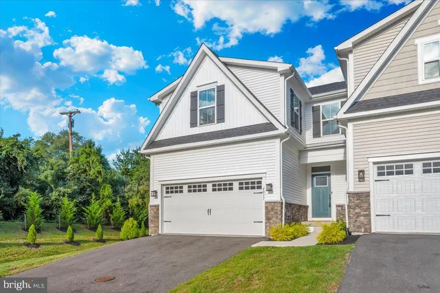 a view of a house with a yard and potted plants