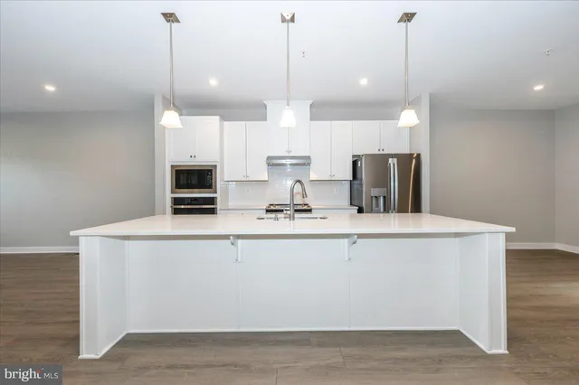 a kitchen with kitchen island a counter top space a sink and appliances
