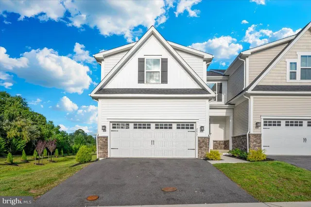 a view of a white house with a yard and potted plants