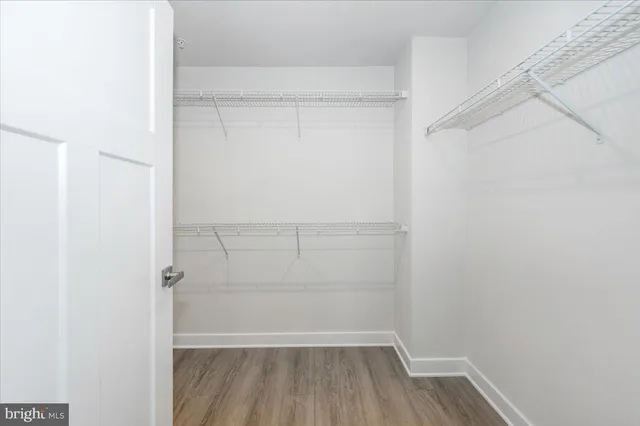 a view of a hallway with wooden floor and a living room