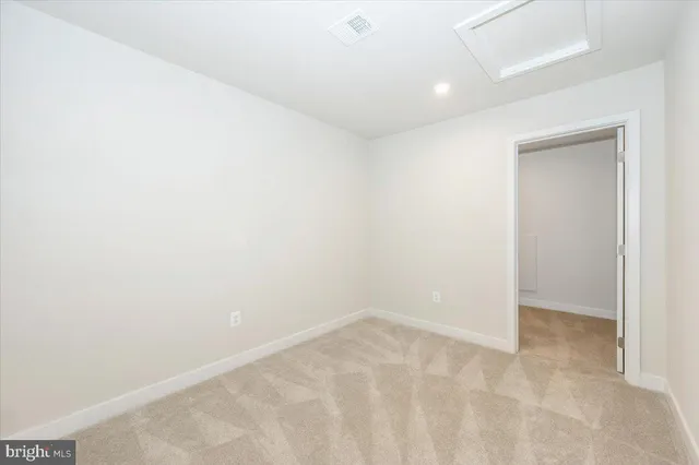 an empty room with a kitchen view and a window