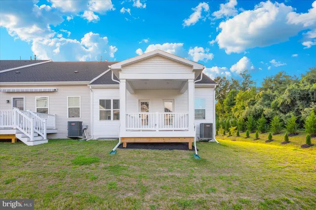 a view of a house with a yard and a large tree