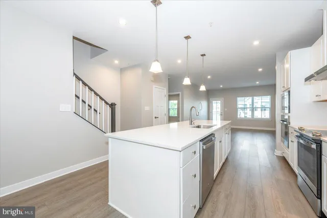 a kitchen with a sink and wooden floor