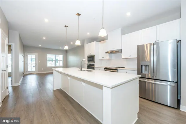 a kitchen with a refrigerator a sink and cabinets