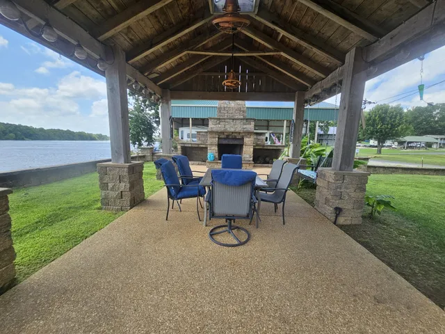 a view of a backyard with table and chairs under an umbrella with a small yard
