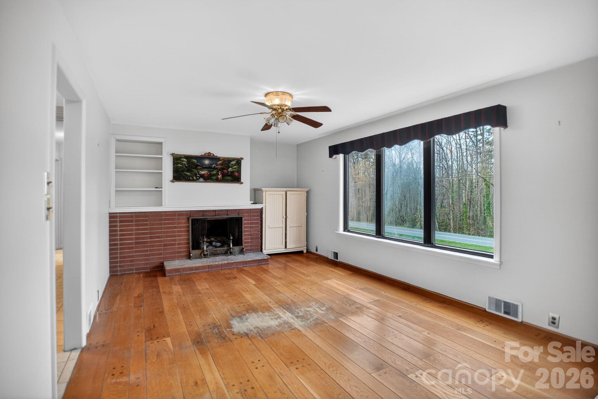 4783 Calico Road Lenoir, NC 28645 - Photo 14 of 44 a view of an empty room with a fireplace and a window