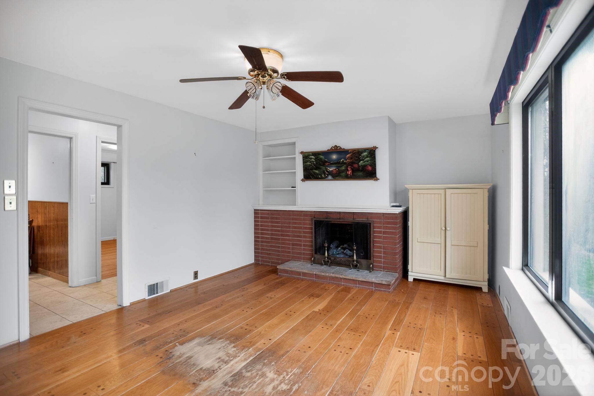4783 Calico Road Lenoir, NC 28645 - Photo 15 of 44 a view of empty room with wooden floor and fireplace