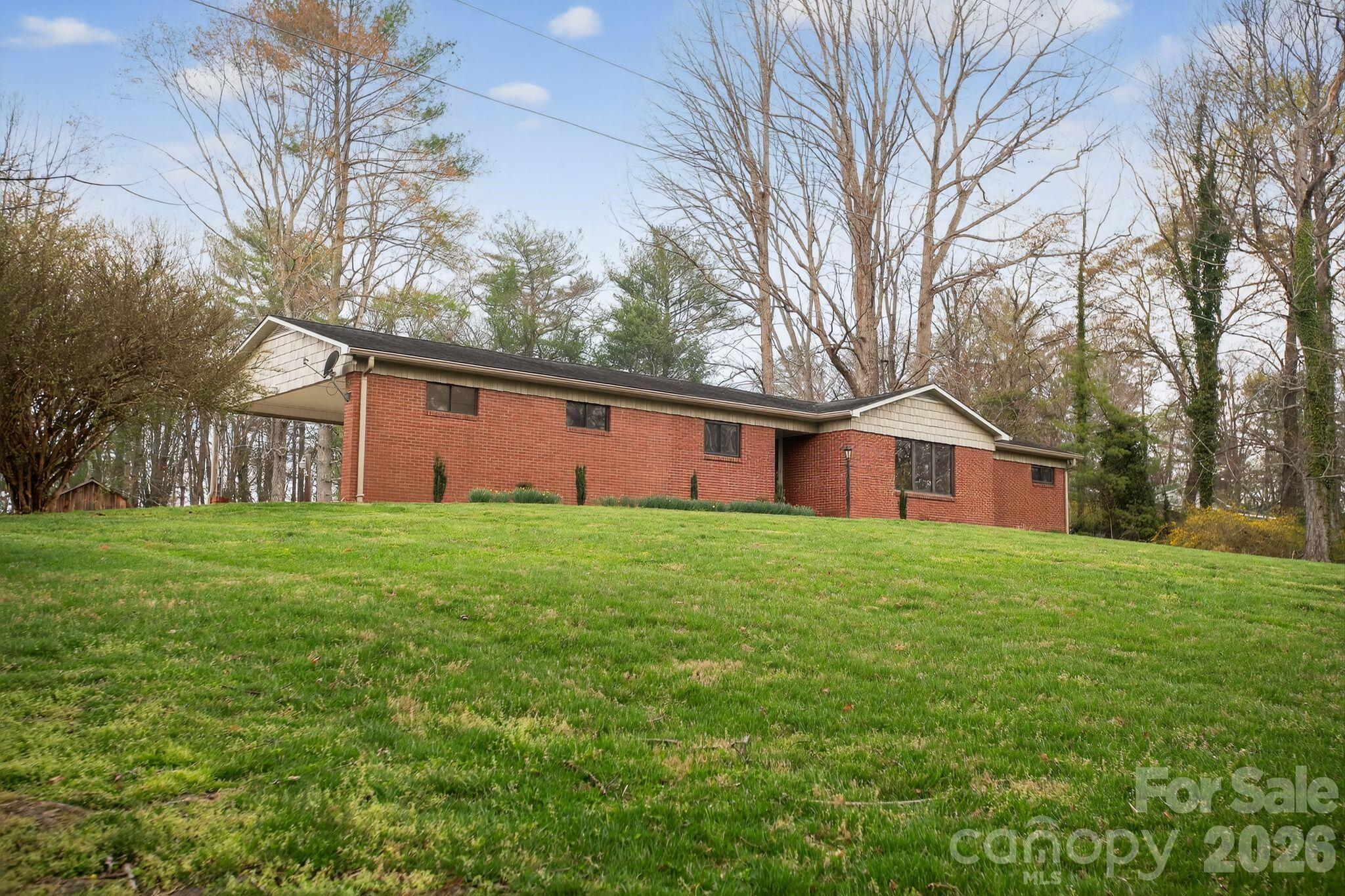 4783 Calico Road Lenoir, NC 28645 - Photo 3 of 44 a view of a yard in front of a house with large trees